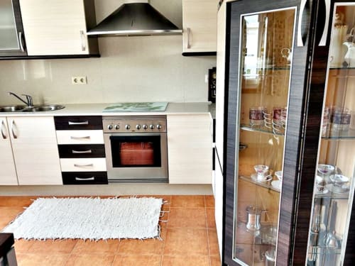 Cocina moderna con electrodomésticos de acero inoxidable y vitrina de cristal en la casita Casa Caeiro, Baiona