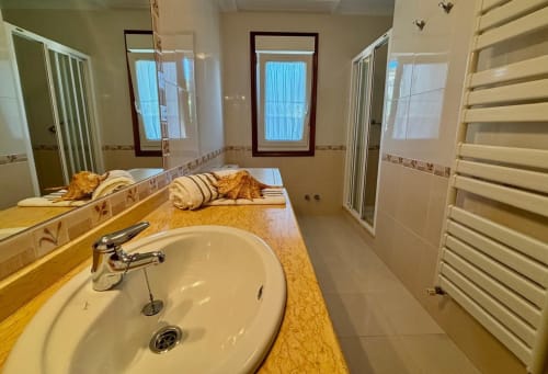Baño espacioso en la casa rural Casa Caeiro cerca de Baiona con encimera de mármol, lavabo redondo y tocador con espejo