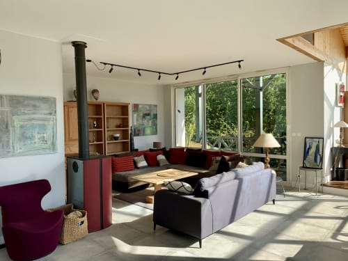 Salon contemporain de Villa Ongizatea à Urrugne avec canapé rouge, cheminée et vue sur le jardin