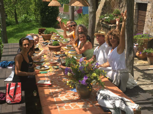 Persone attorno ad un tavolo che mangiano in agriturismo in una giornata soleggiata