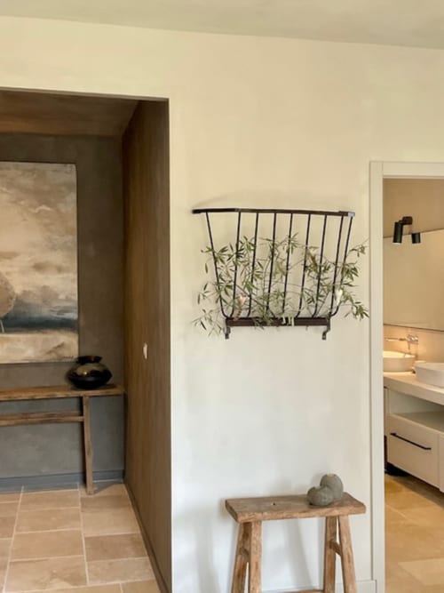 Couloir minimaliste de la chambre The Cypresses à Provence Km28 B&B, Gordes, avec panier mural en métal et banc en bois rustique