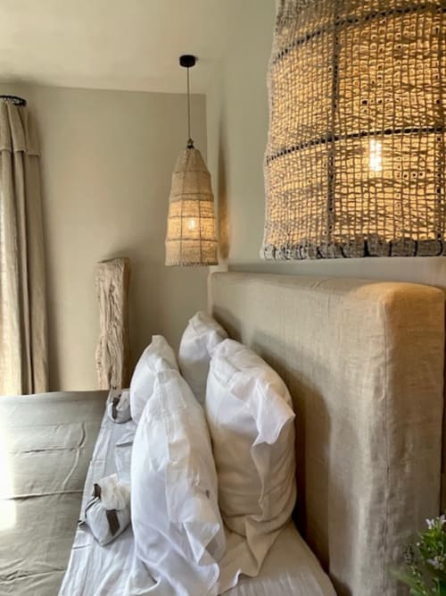 Chambre accueillante à Provence Km28 à Gordes avec lit capitonné beige, oreillers blancs, suspension tissée et décoration raffinée