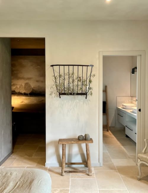 Couloir de la chambre Cyprès, Provence Km28 à Gordes avec tabouret en bois, plantes en pots et portes vers salle de bain et chambre