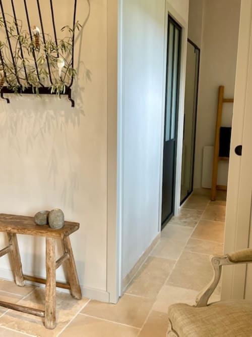 Couloir moderne aux murs crème, carrelage en terre cuite, mobilier en bois et plante suspendue à Provence Km28 à Gordes