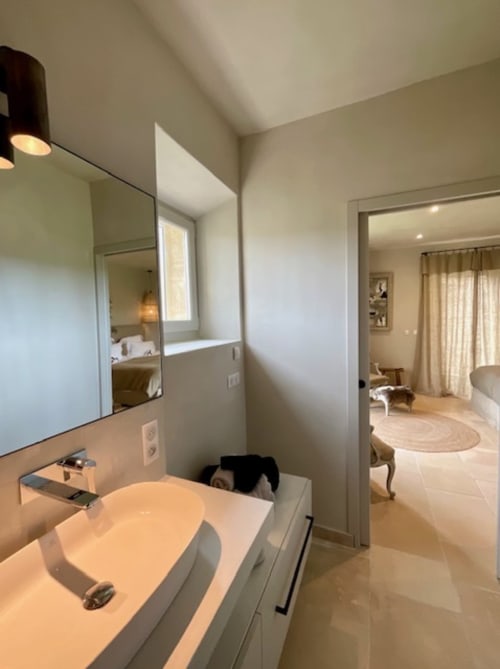 Salle de bain moderne à Provence Km28 Gordes avec lavabo blanc, miroir et accès à la suite chambre