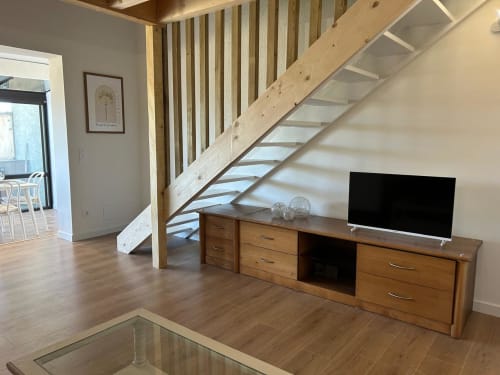 Séjour moderne à Mazet Cavalaire avec meuble TV en bois, escalier et layout ouvert à Cavalaire-sur-Mer