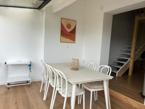 Salle à manger moderne de l'hôtel Mazet Cavalaire avec table blanche, chaises et escalier à Cavalaire-sur-Mer