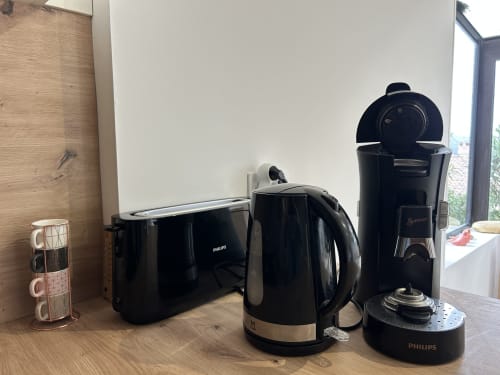 Électroménagers de l'hôtel Mazet Cavalaire : grille-pain, bouilloire et cafetière Philips sur plan de travail en bois
