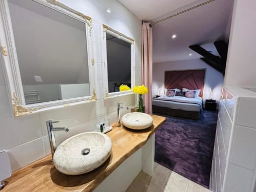 Sink and a view of bed in one room | Experience Elegance in the Prestige Room at Domaine Pont Juillet