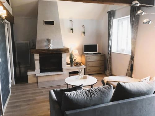 Living area with chimney, sofa chair and television | Spacious and Elegant – The Family Loft Suite Awaits You