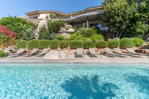 Piscine luxueuse à la Villa Marina Di Cavu à Bonifacio avec chaises longues, eau turquoise et élégante villa méditerranéenne