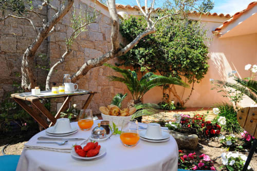 Table de petit-déjeuner avec fruits frais et jus de fruits sur la terrasse du jardin de Villa Marina Di Cavu, Bonifacio