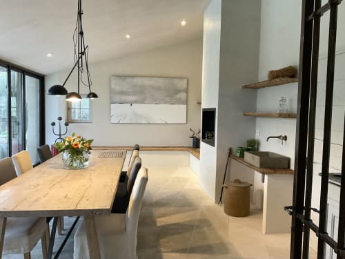 Modern keuken- en eetgedeelte in Provence Km28 B&B in Gordes met houten tafel, witte kastjes en hangende verlichting