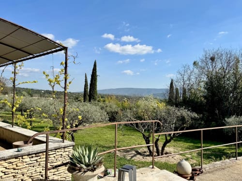 Toscaans wijngaardlandschap bij Provence Km28 B&B in Gordes met cipressen, olijfgaarden en glooiende heuvels onder blauwe hemel