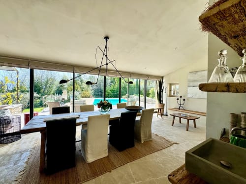 Modern eetgedeelte van Provence Km28 in Gordes met zwembadzicht, eigentijdse kroonluchter en elegante tafelschikking