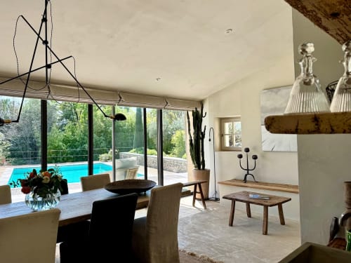 Moderne eetkamer bij Provence Km28 in Gordes met uitzicht op het zwembad, rustiek houten meubilair en eigentijds kroonluchter