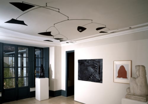 Modern gallery space at Domaine de l'Ocrerie in Pourrain with art installations and geometric mobile sculpture