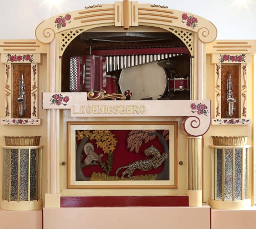 Vintage L. Koenigsberg fairground organ display with ornate wood frame and burgundy decorative details