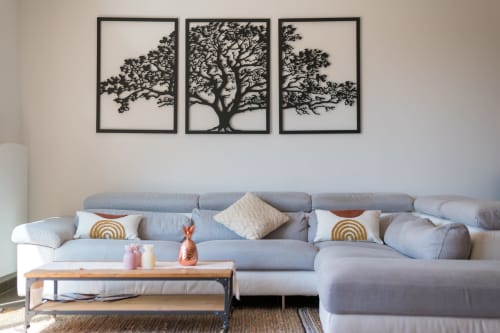 Salon moderne de Maison Love Lane avec canapé gris, table basse en bois et trois silhouettes d'arbres noirs au mur
