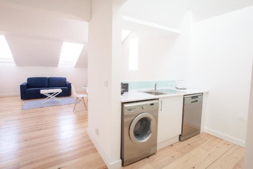 Kitchen with washing machine and living area | Experience Comfort and Style at Loving Chiado 1 in Lisbon