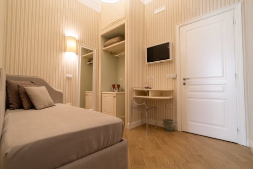 Camera tripla Florita Napoli presso Le Boutique del Centro con letto, armadio, scrivania e TV a Napoli