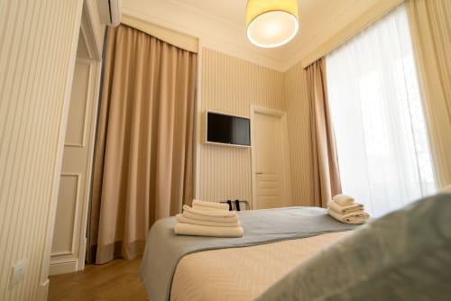 Camera moderna dell'Hotel Le Boutique del Centro a Napoli con letto, TV a schermo piatto e vista sulla città