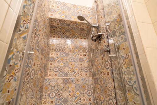 Moderna cabina doccia con piastrelle decorate in toni caldi presso l'Hotel Le Boutique del Centro a Napoli