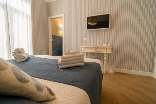 Camera da letto moderna e doppia presso Le Boutique del Centro a Napoli con TV, scrivania in legno e bagno privato