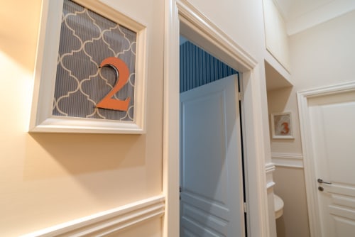 Corridoio della boutique del Centro di Napoli con porta numero 2 e finiture moderne in bianco