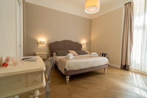 Camera da letto executive elegante al Le Boutique del Centro di Napoli con letto queen, scrivania, illuminazione ambientale e vista sulla città