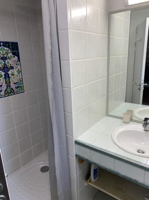 Modern shared bathroom in Villa Ongizatea B&B, Urrugne, with white tiles, sink, shower area and glass enclosure