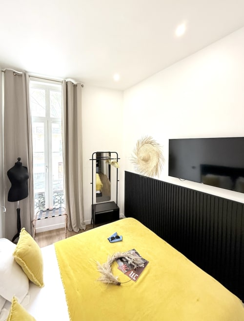 Camera moderna al Boutique Hôtel Provencia di Marsiglia con letto giallo, pannelli neri, TV e vista sulla città