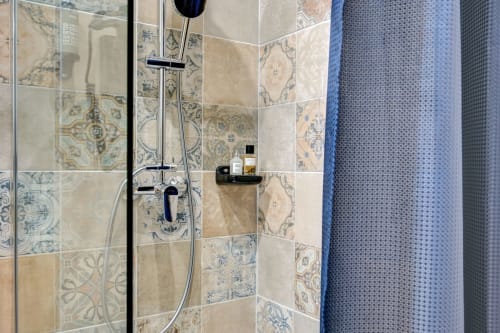 Cabina doccia con piastrelle decorative blu e beige al Boutique Hôtel Provencia di Marsiglia