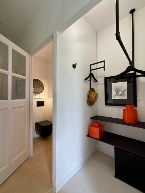 Modern bathroom at Provence Km28 in Gordes with floating black shelves, red accessories, and minimalist décor