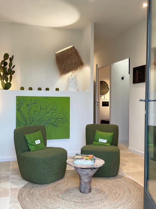 Modern sitting area in Les Oliviers room at Provence Km28 with green armchairs, garden-view wall art, and cactus decor in