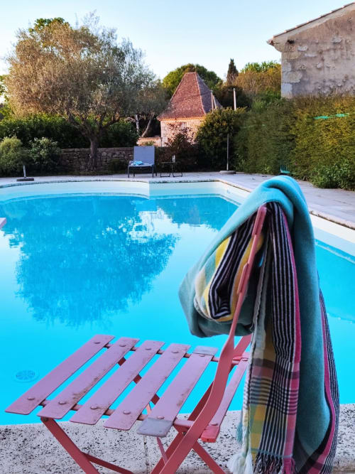 Piscine extérieure ensoleillée de la chambre d'hôtes de charme "Le Rêve d'Alice" avec mobilier de jardin et végétation méditerranéenne en arrière-plan.
