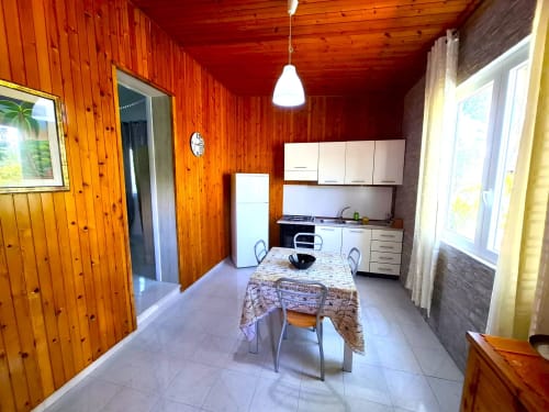 Cucina dell'appartamento Newhouse a Bari con pareti in legno, tavolo da pranzo e elettrodomestici moderni