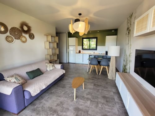 Modern 45m² villa living room at Villas Lantana Lecci with sofa, kitchen, dining area and flat-screen TV