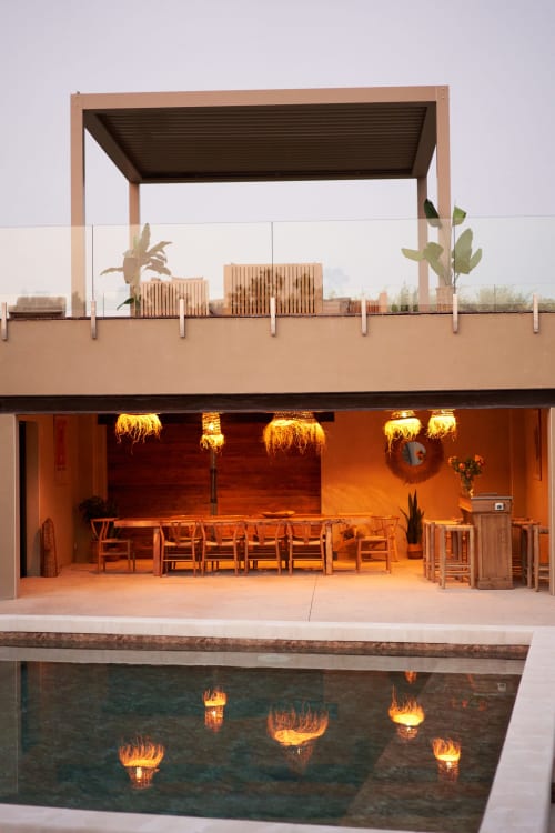 Terraza de La Maison D'ambrine con zona de comedor, chimenea iluminada, reflejo de la piscina, Chamaret