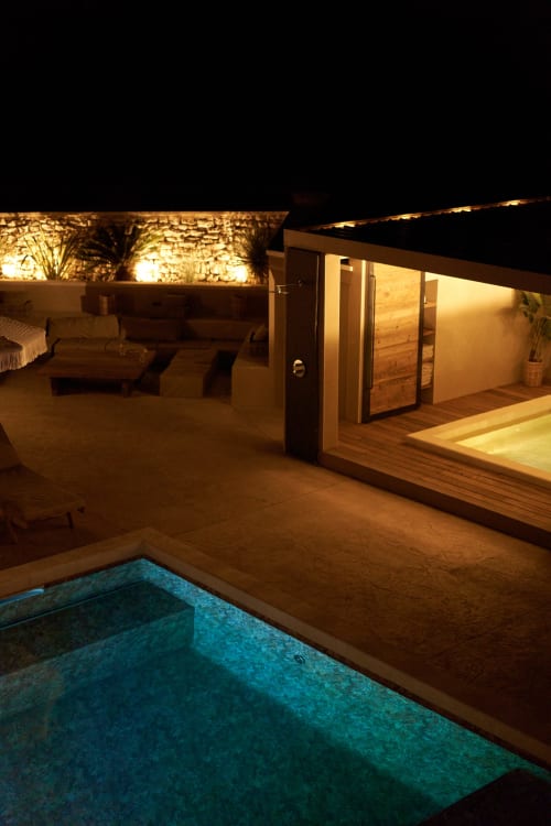 Terraza de La Maison D'ambrine por la noche con piscina iluminada, zona de descanso y arquitectura moderna en Chamaret