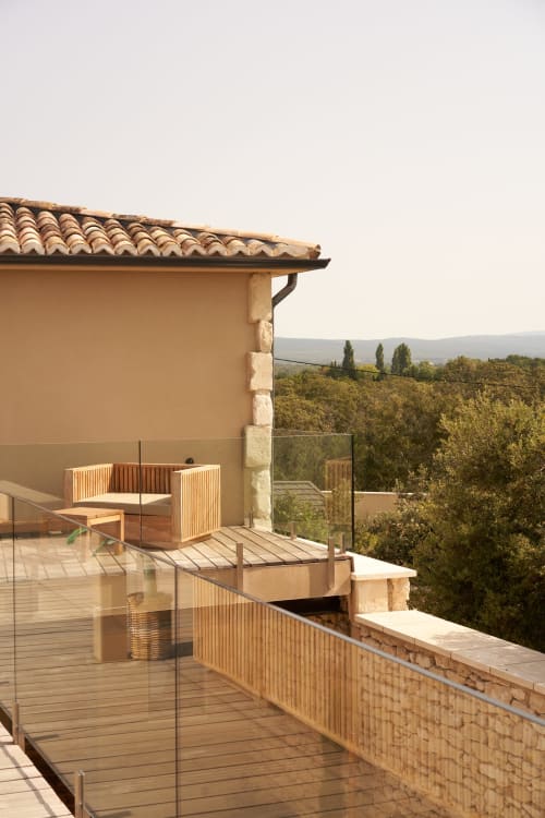 Terraza de estilo toscano en La Maison D'Ambrine con tarima de madera, mobiliario moderno y vistas al campo cerca de Chamaret, Francia