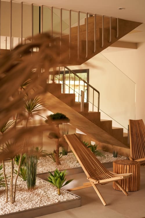 Escalera moderna con escalones de madera y barandilla metálica en La Maison D'ambrine B&B en Chamaret, con plantas y zona de descanso