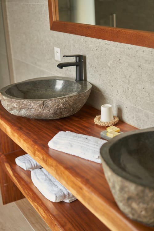 Lavabo moderno de piedra en La Villa Ibiza con grifo negro y toallas blancas sobre encimera de madera
