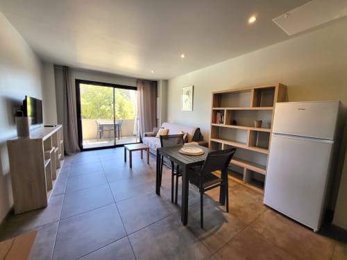 Modern 1-bedroom apartment at Villas Lantana in Lecci with kitchen, dining area, and balcony access