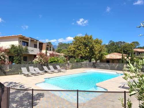 Villas Lantana pool area in Lecci with loungers, Mediterranean villa, clear blue water, and mountain views