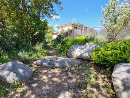 Sentiero di giardino con massi alle Villas Lantana, boutique hotel a Lecci, circondato da vegetazione mediterranea