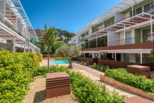 Patio de complejo residencial moderno en Palafrugell con piscina, zonas verdes y terrazas soleadas