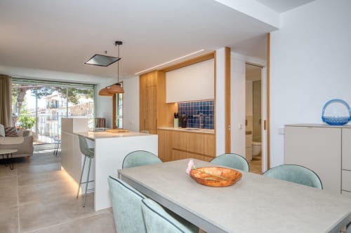 Cocina moderna y comedor en Finques Garcia Enrich en Palafrugell con mobiliario de madera y vistas al mar