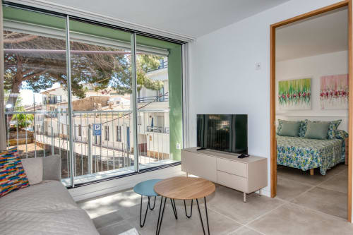 Suite moderna en Finques Garcia Enrich en Palafrugell con balcón, sala de estar, televisión y dormitorio