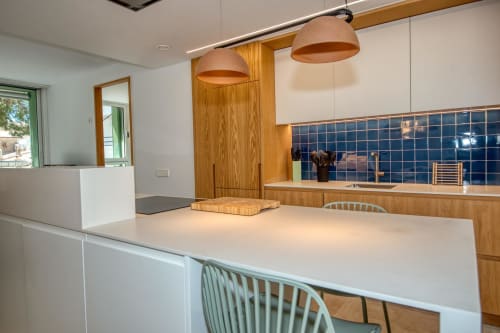Cocina y comedor modernos del hotel Finques Garcia Enrich en Palafrugell con acabados de madera y azulejos azules de salpicaduras